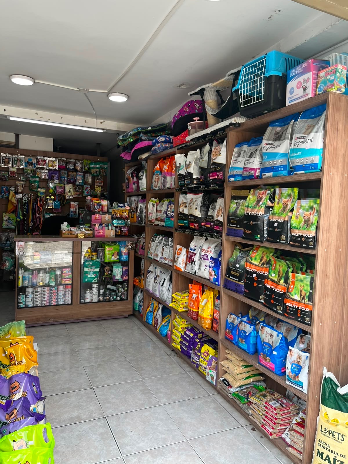 Estantería con alimento para gatos y arena sanitaria en la tienda MASCOTASTORE de Alta Suiza, Manizales